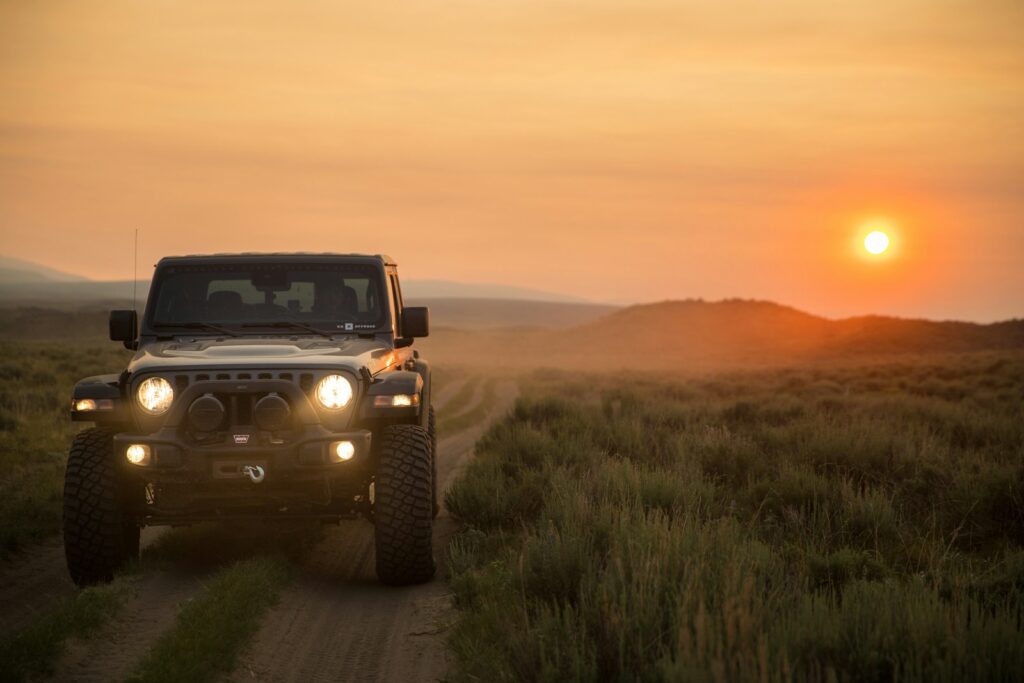 jeep gladiator on a dusty trail during sunset