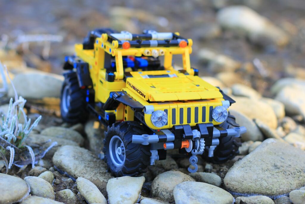 a yellow toy truck sitting on top of a pile of rocks