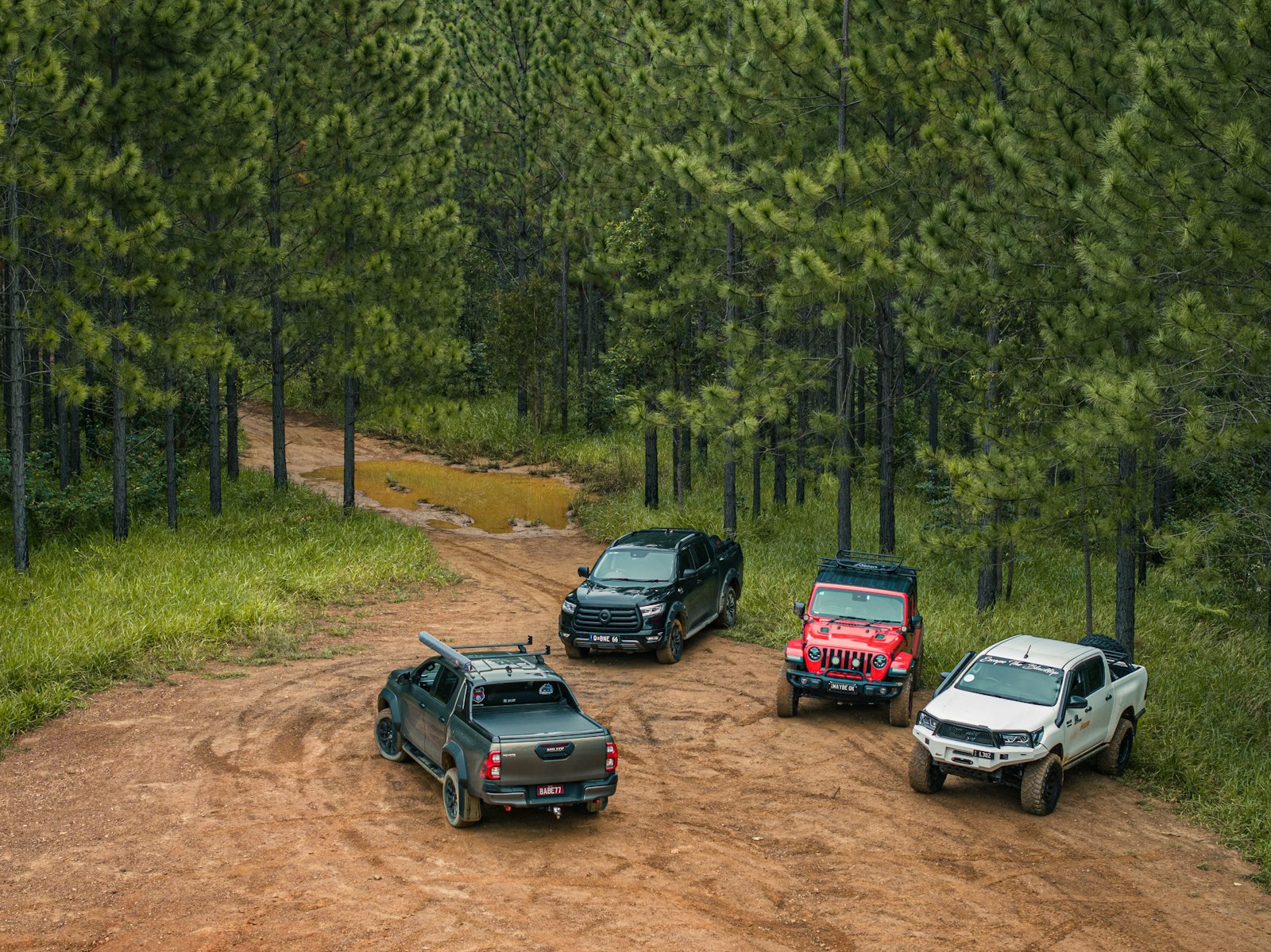 Four off-road vehicles parked on a dirt road