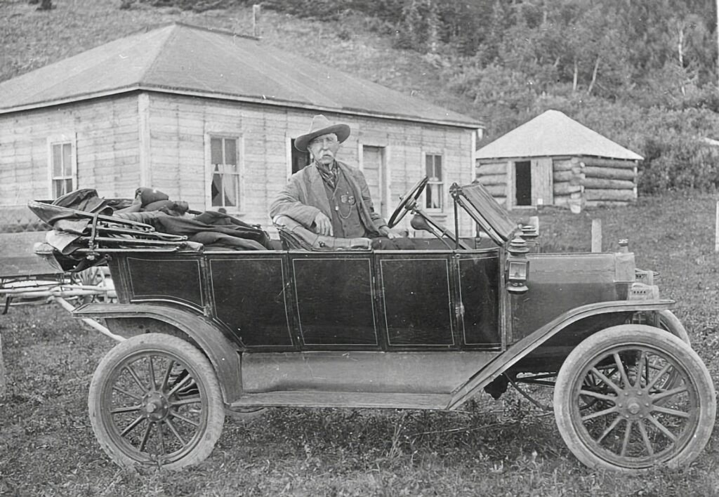 a man sitting in an old fashioned car