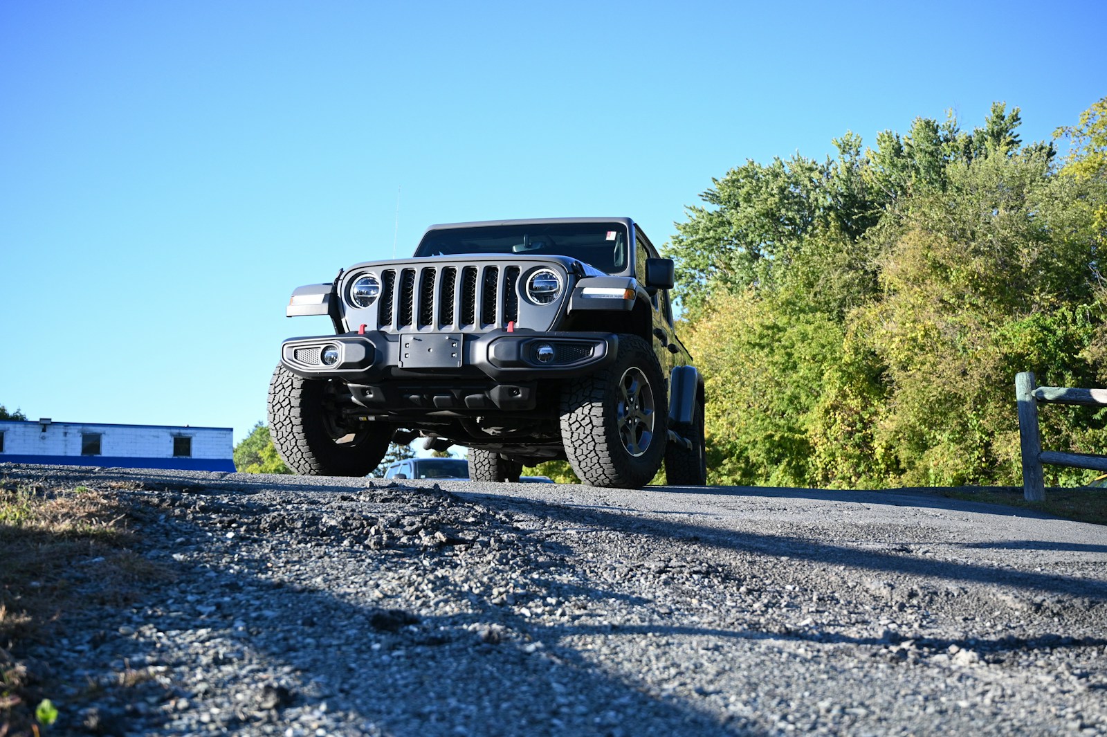 a black jeep driving down a road next to a forest