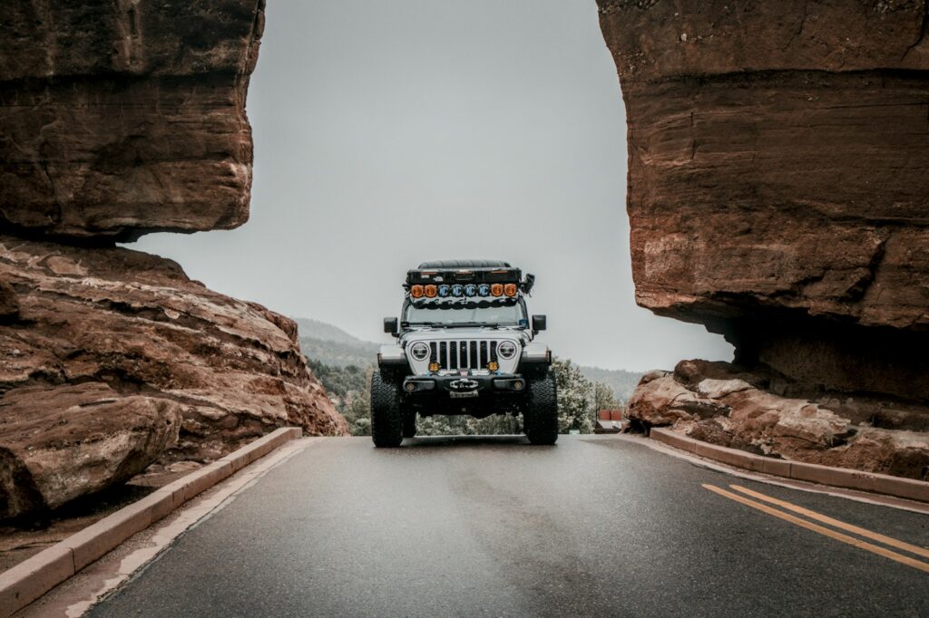 A jeep driving through a gap in the rocks